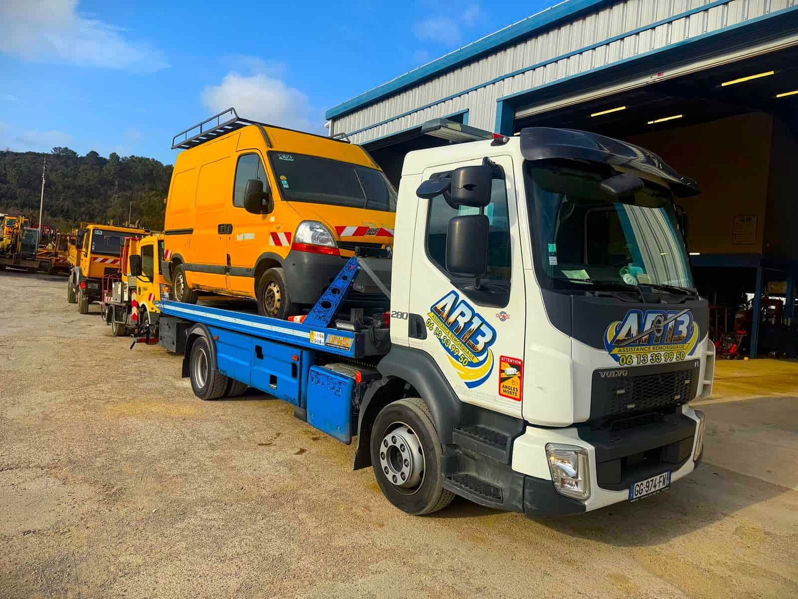 Dépanneuse transportant une voiture sur plateau